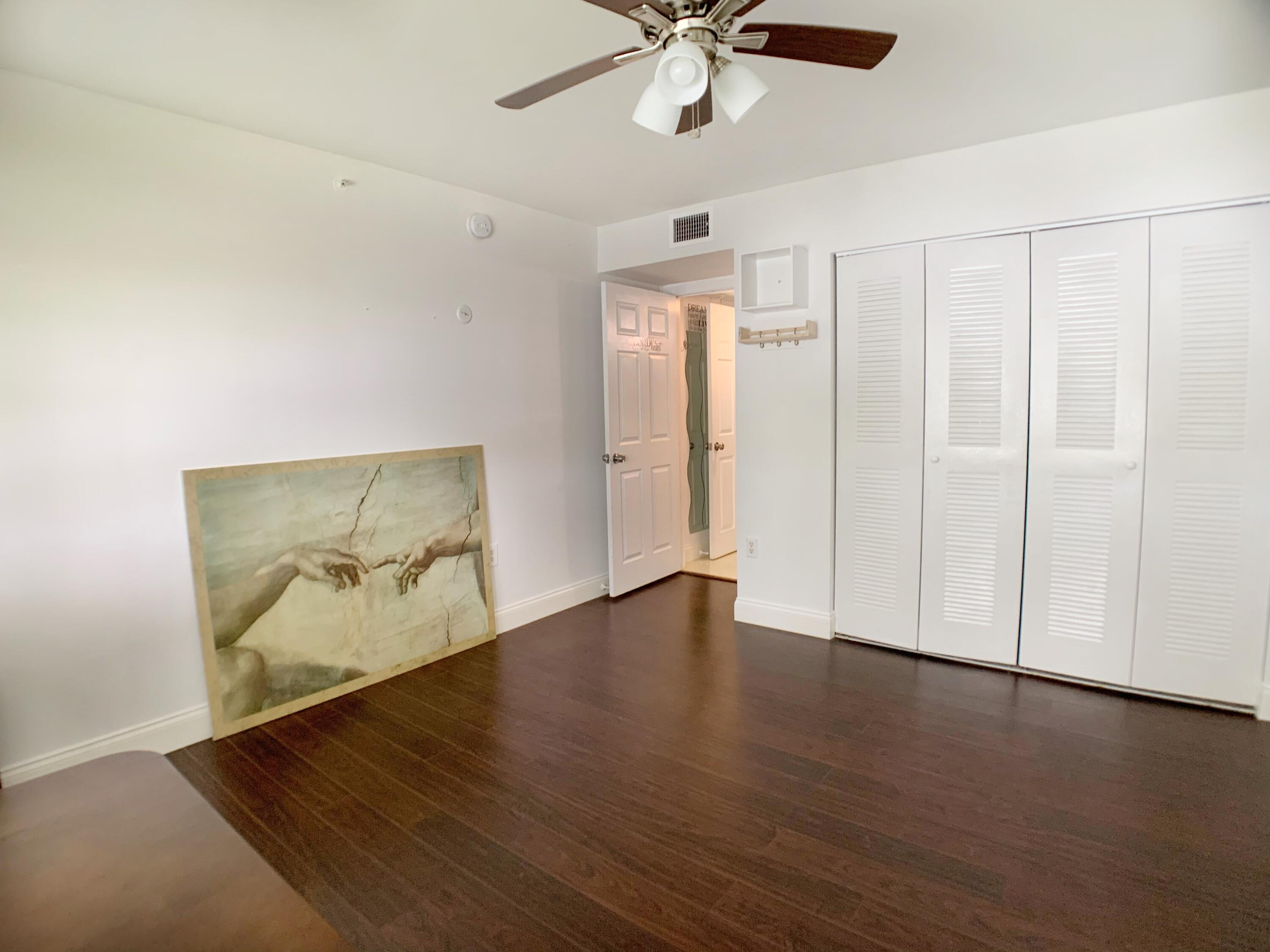 5015 Wiles Road, Unit 206 Coconut Creek, FL 33073 - Photo 26 of 32 an empty room with wooden floor closet and windows