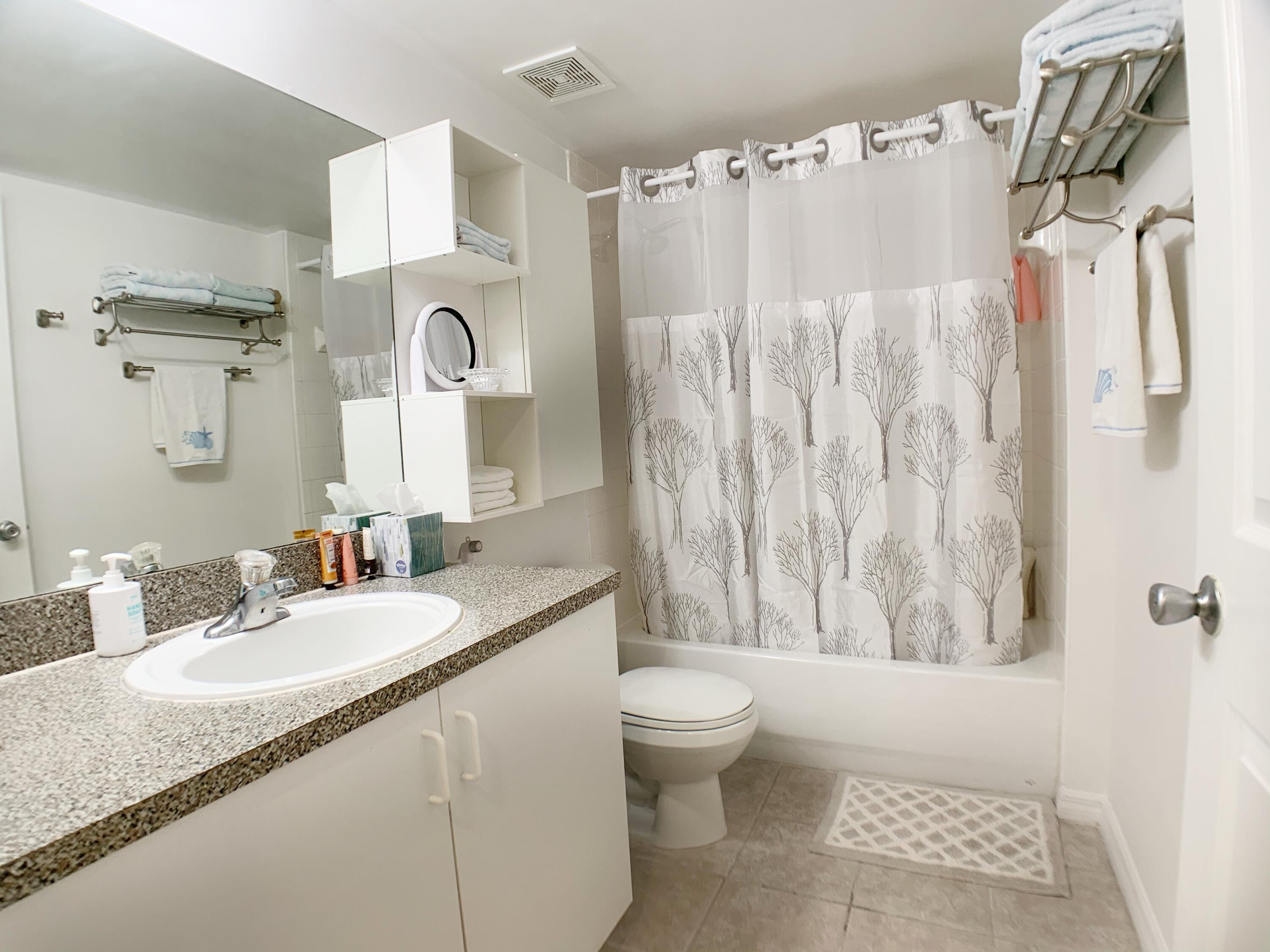 5015 Wiles Road, Unit 206 Coconut Creek, FL 33073 - Photo 28 of 32 a bathroom with a granite countertop sink and a mirror
