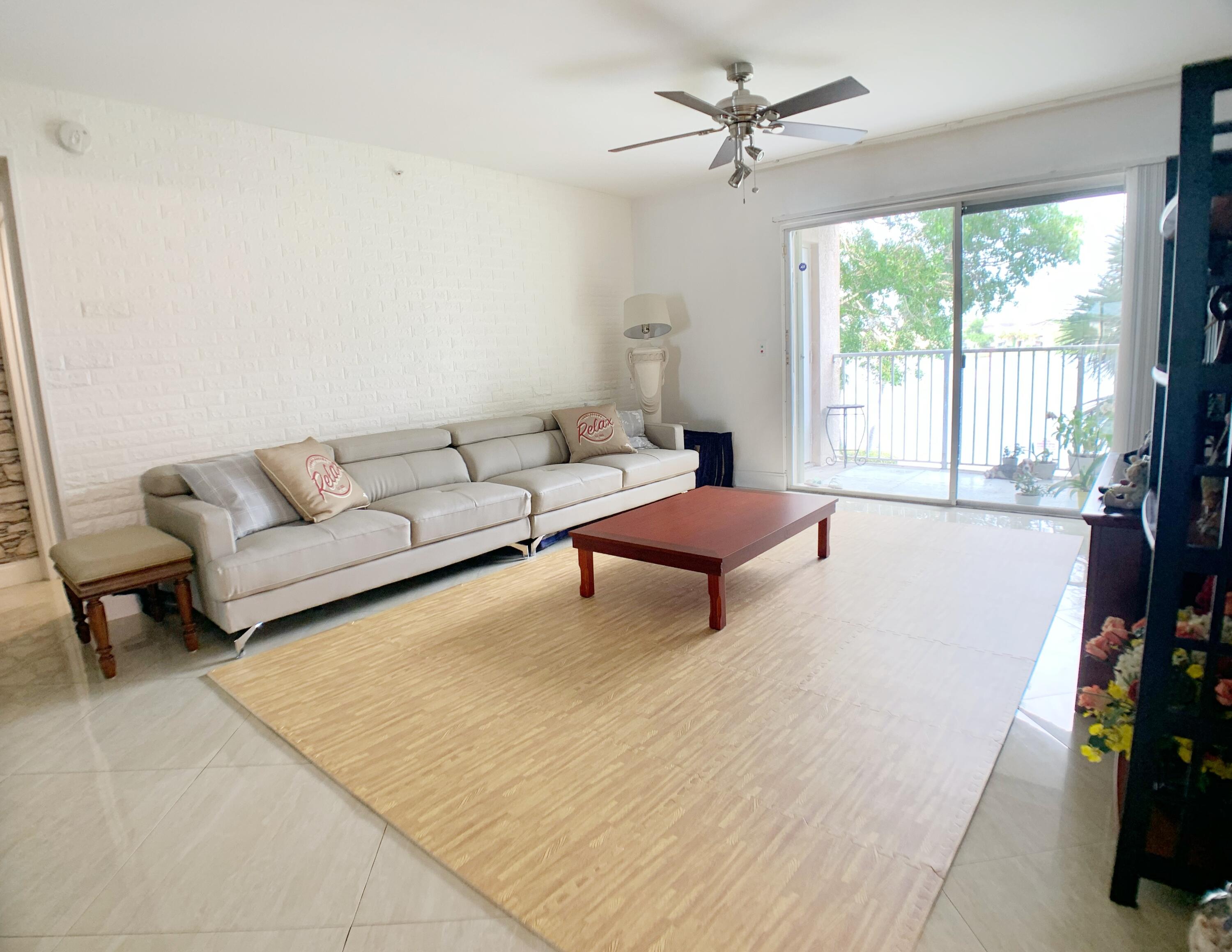 5015 Wiles Road, Unit 206 Coconut Creek, FL 33073 - Photo 4 of 32 a living room with furniture and a fireplace