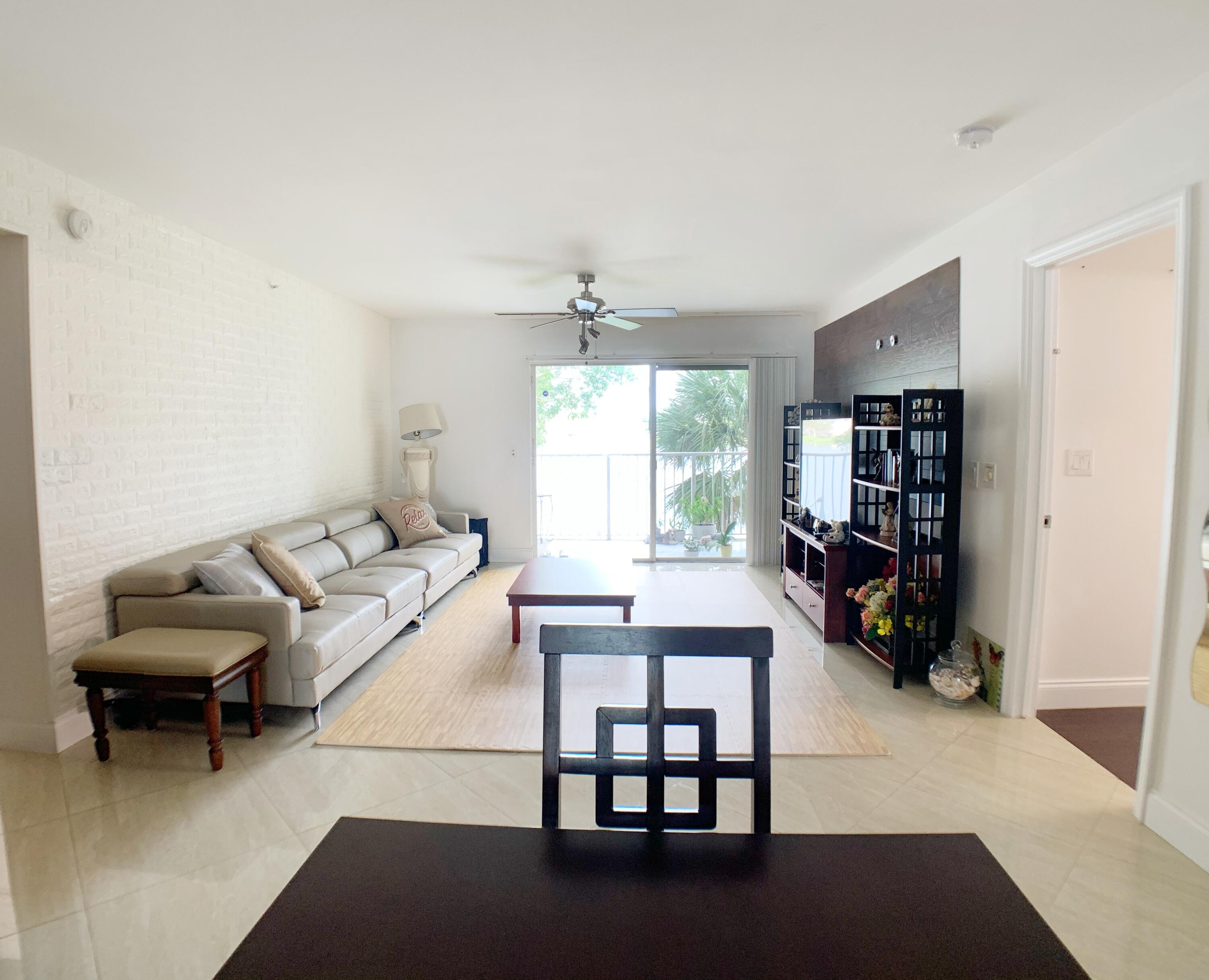 5015 Wiles Road, Unit 206 Coconut Creek, FL 33073 - Photo 8 of 32 a living room with furniture and a window