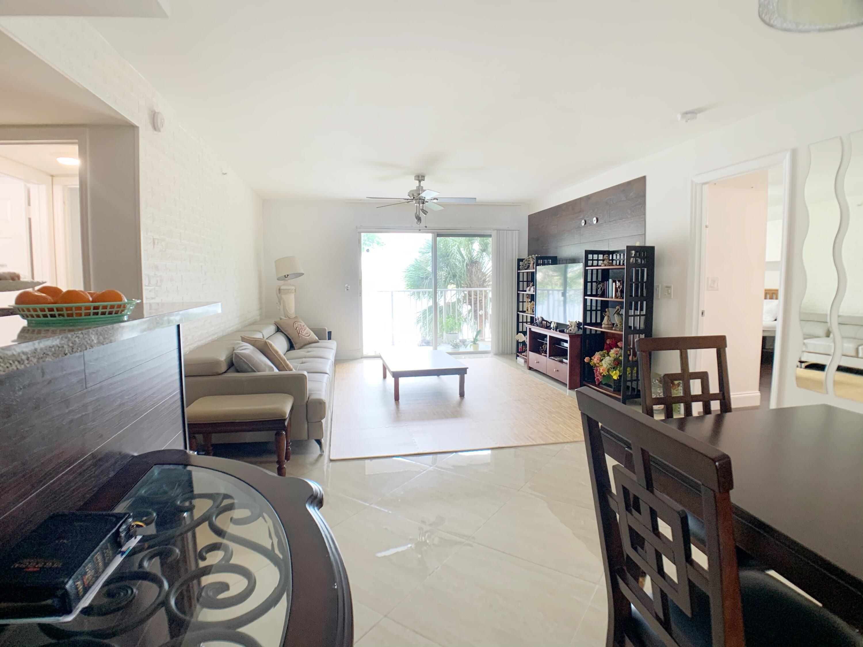 5015 Wiles Road, Unit 206 Coconut Creek, FL 33073 - Photo 10 of 32 a living room with furniture and a wooden floor
