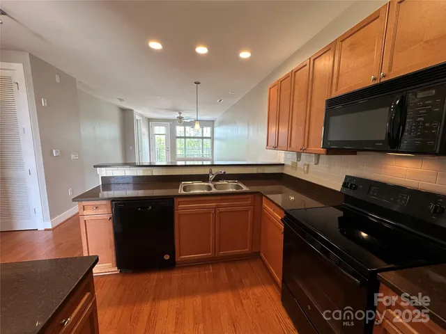 a kitchen with stainless steel appliances kitchen island granite countertop a stove a sink and a microwave