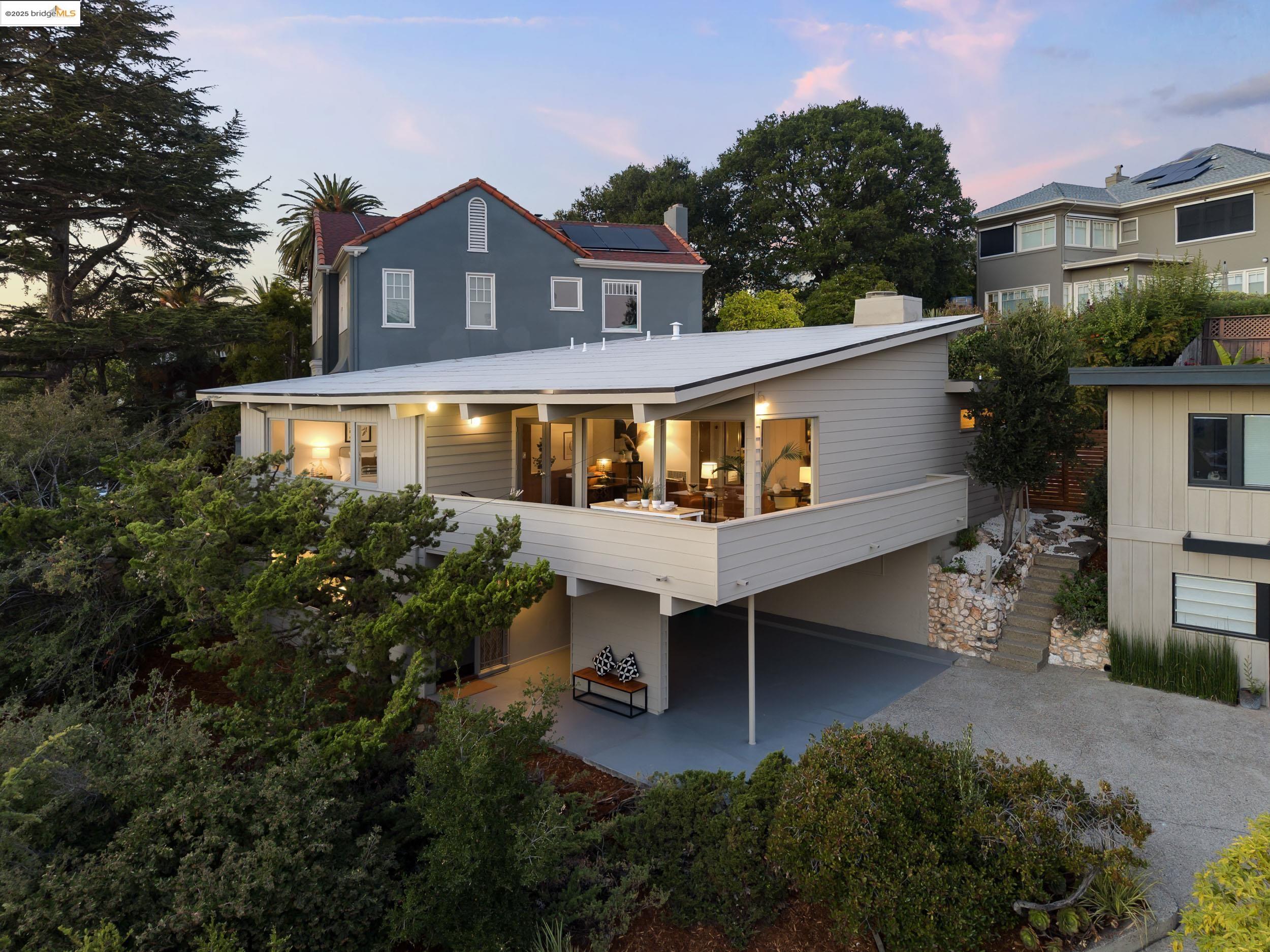 99 Eucalyptus Road Berkeley, CA 94705 - Photo 1 of 1 Back of house at dusk with a patio, solar panels, and a carport