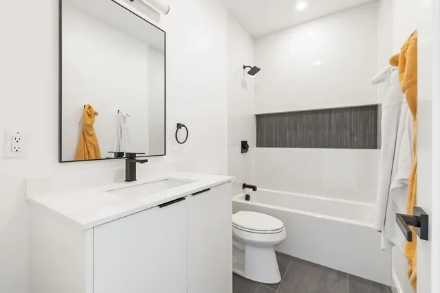 a bathroom with a sink a toilet and a mirror