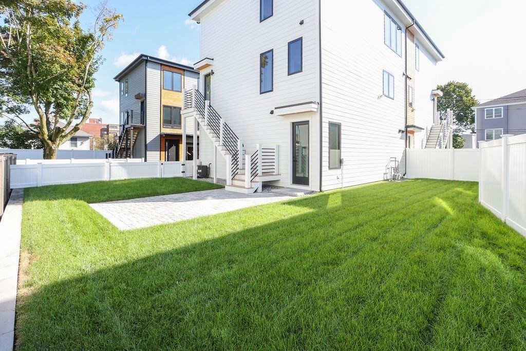 31 Hall Street, Unit 2 Waltham, MA 02453 - Photo 20 of 23 a view of a white house with a big yard and large trees