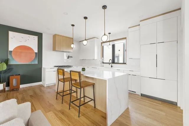 a kitchen with stainless steel appliances granite countertop a sink a stove and a wooden floors