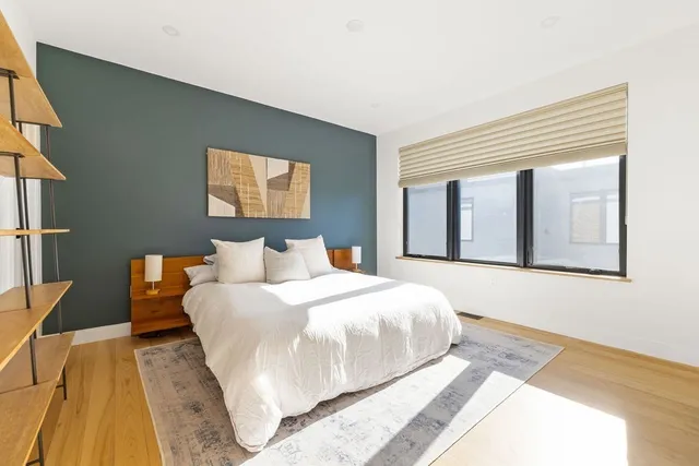 a bedroom with a large bed and a flat tv screen on dresser