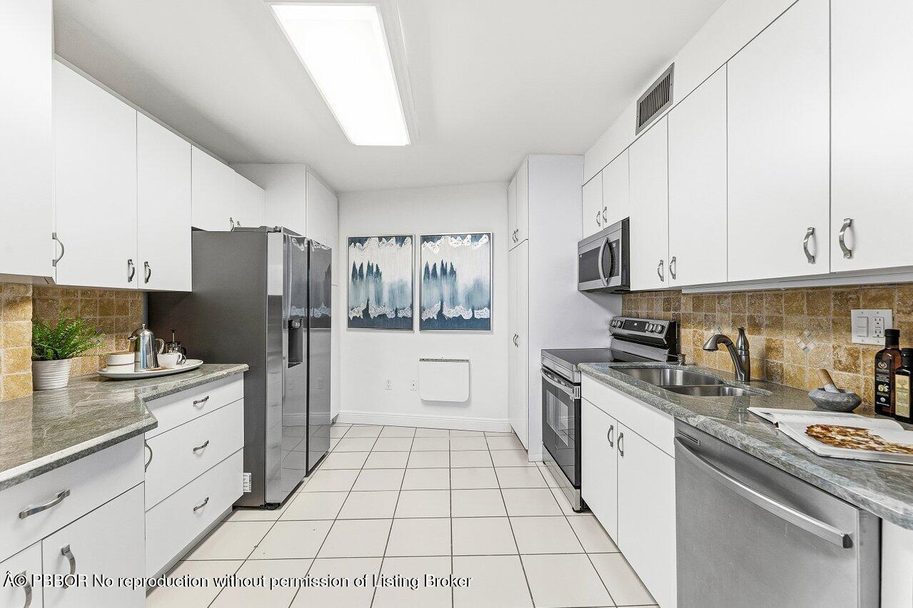 44 Cocoanut Row, Unit 120B Palm Beach, FL 33480 - Photo 12 of 42 a kitchen with stainless steel appliances a refrigerator sink stove and cabinets