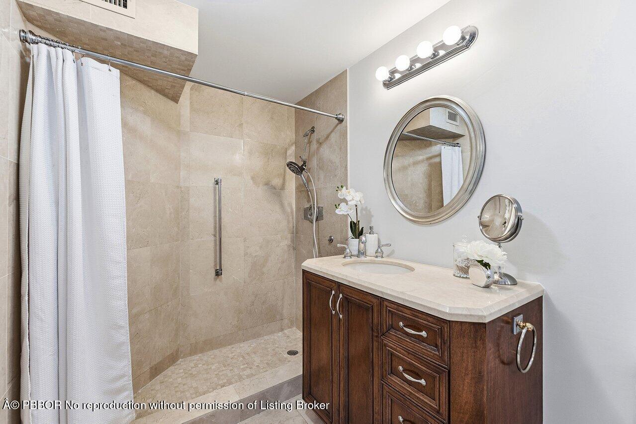 44 Cocoanut Row, Unit 120B Palm Beach, FL 33480 - Photo 20 of 42 a bathroom with a sink vanity granite and a mirror