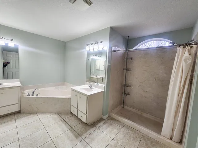 a bathroom with a bathtub a mirror and a shower