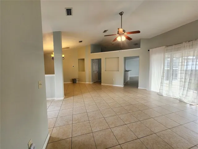 a view of a livingroom with a chandelier fan and windows