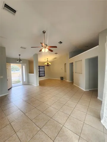 an empty room with a kitchen space and a window