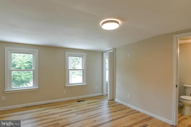 a view of a room with wooden floor and a bathroom
