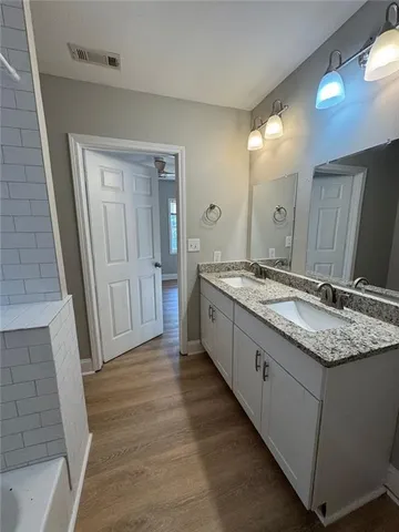a bathroom with a granite countertop sink and a mirror