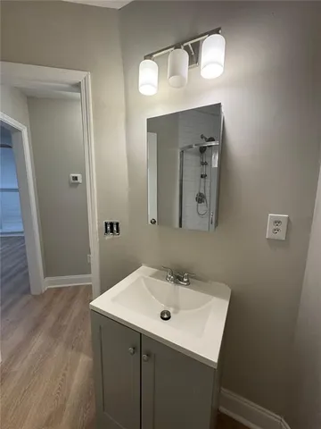 a bathroom with a sink a light fixture and a mirror
