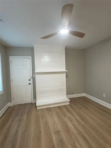 an empty room with wooden floor & cabinet and mirrors