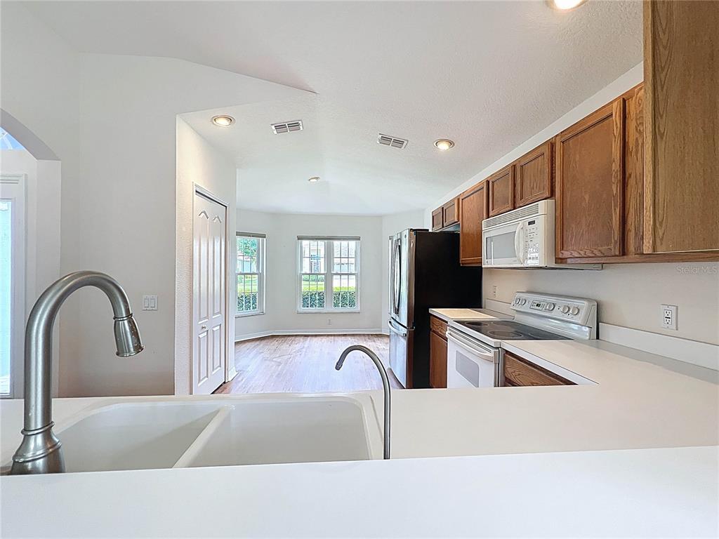 11644 Spindrift Loop Hudson, FL 34667 - Photo 11 of 99 a large kitchen with stainless steel appliances granite countertop a stove a sink a refrigerator and cabinets