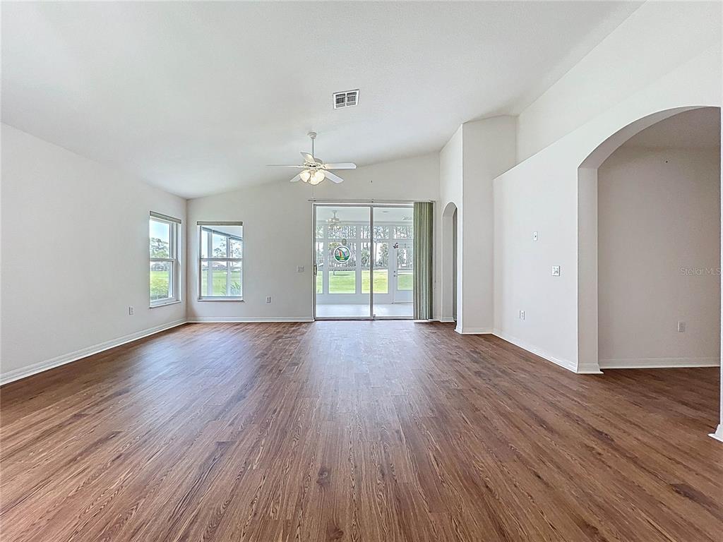 11644 Spindrift Loop Hudson, FL 34667 - Photo 17 of 99 an empty room with wooden floor and windows