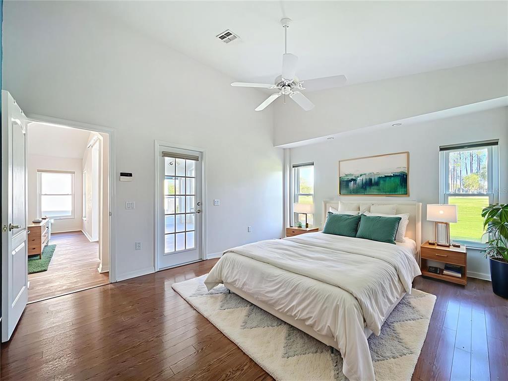11644 Spindrift Loop Hudson, FL 34667 - Photo 25 of 99 a bedroom with a large bed and a chandelier
