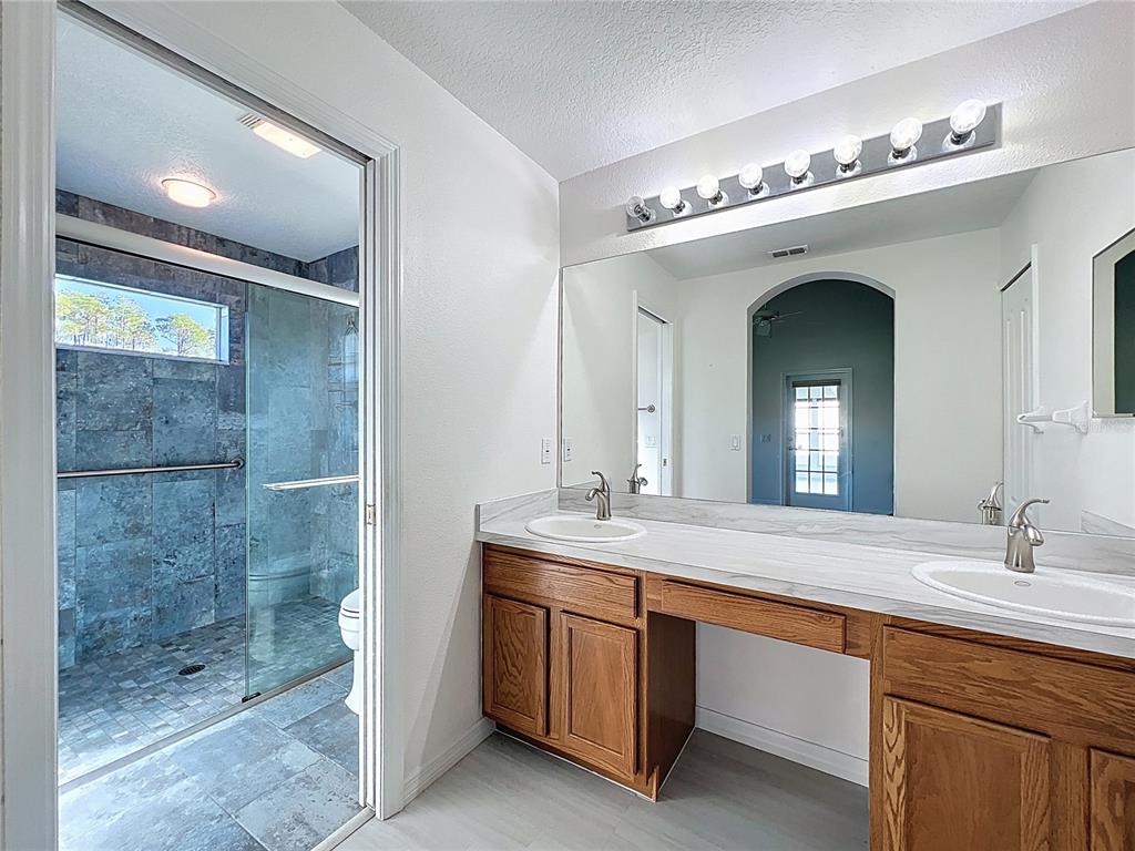 11644 Spindrift Loop Hudson, FL 34667 - Photo 31 of 99 a bathroom with a double vanity sink and a mirror