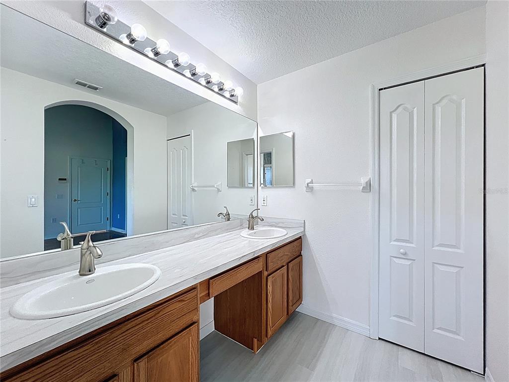 11644 Spindrift Loop Hudson, FL 34667 - Photo 34 of 99 a bathroom with a double vanity sink and a mirror