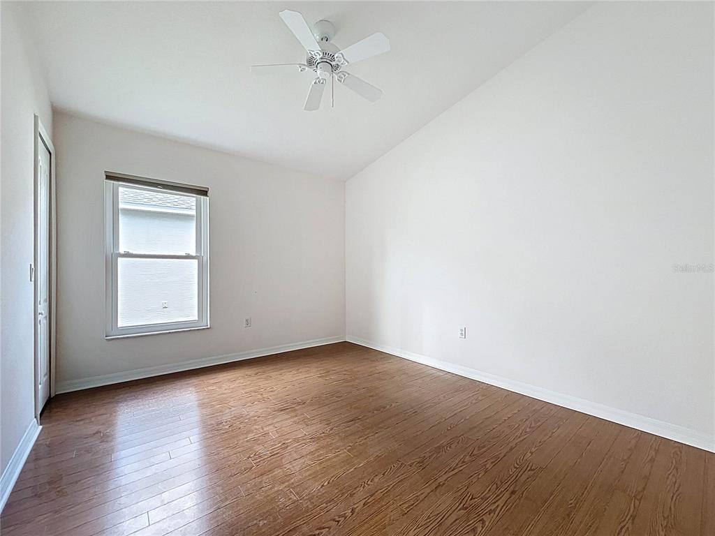 11644 Spindrift Loop Hudson, FL 34667 - Photo 40 of 99 an empty room with wooden floor chandelier fan and windows
