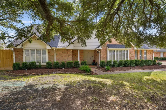 a front view of a house with a yard and trees