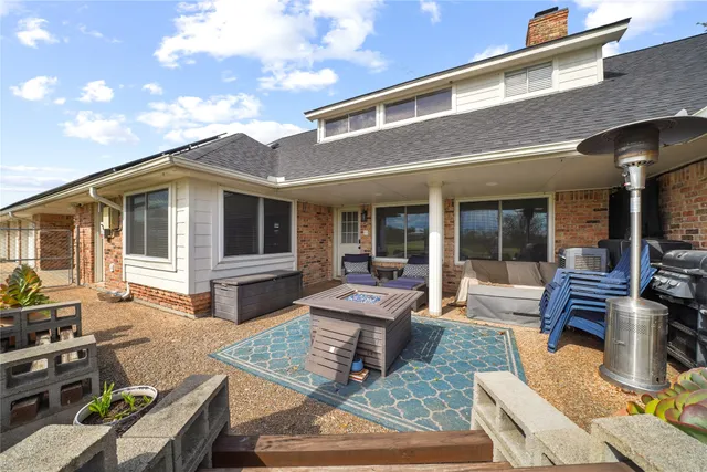 a view of a house with backyard sitting area and furniture