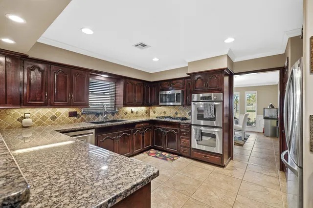a kitchen with a sink a stove top oven and cabinetry