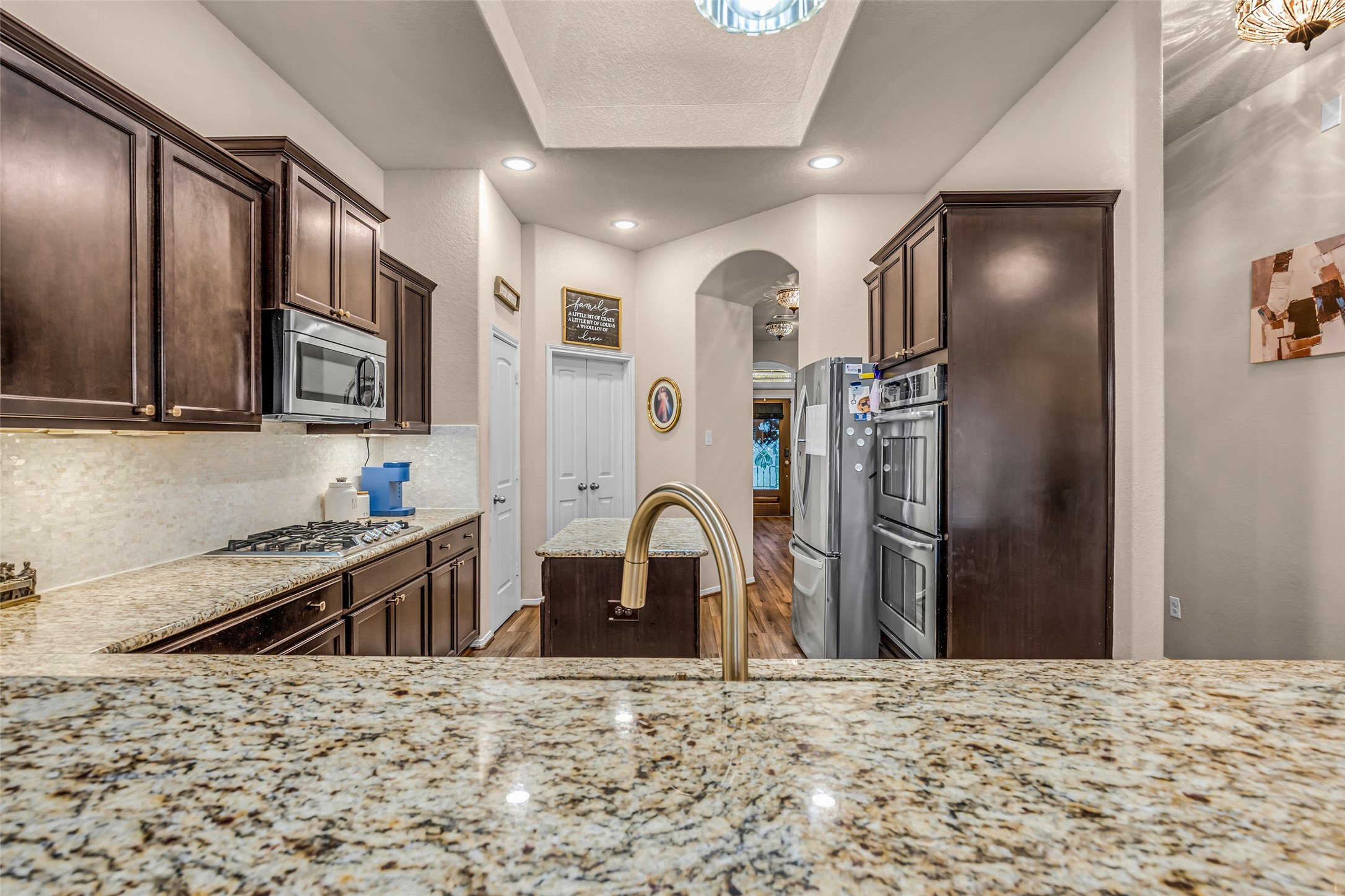 22907 Banff Brook Way Tomball, TX 77375 - Photo 10 of 26 A full view of the kitchen from the breakfast bar highlights the overall layout, along with a pantry conveniently tucked into the corner for additional storage.