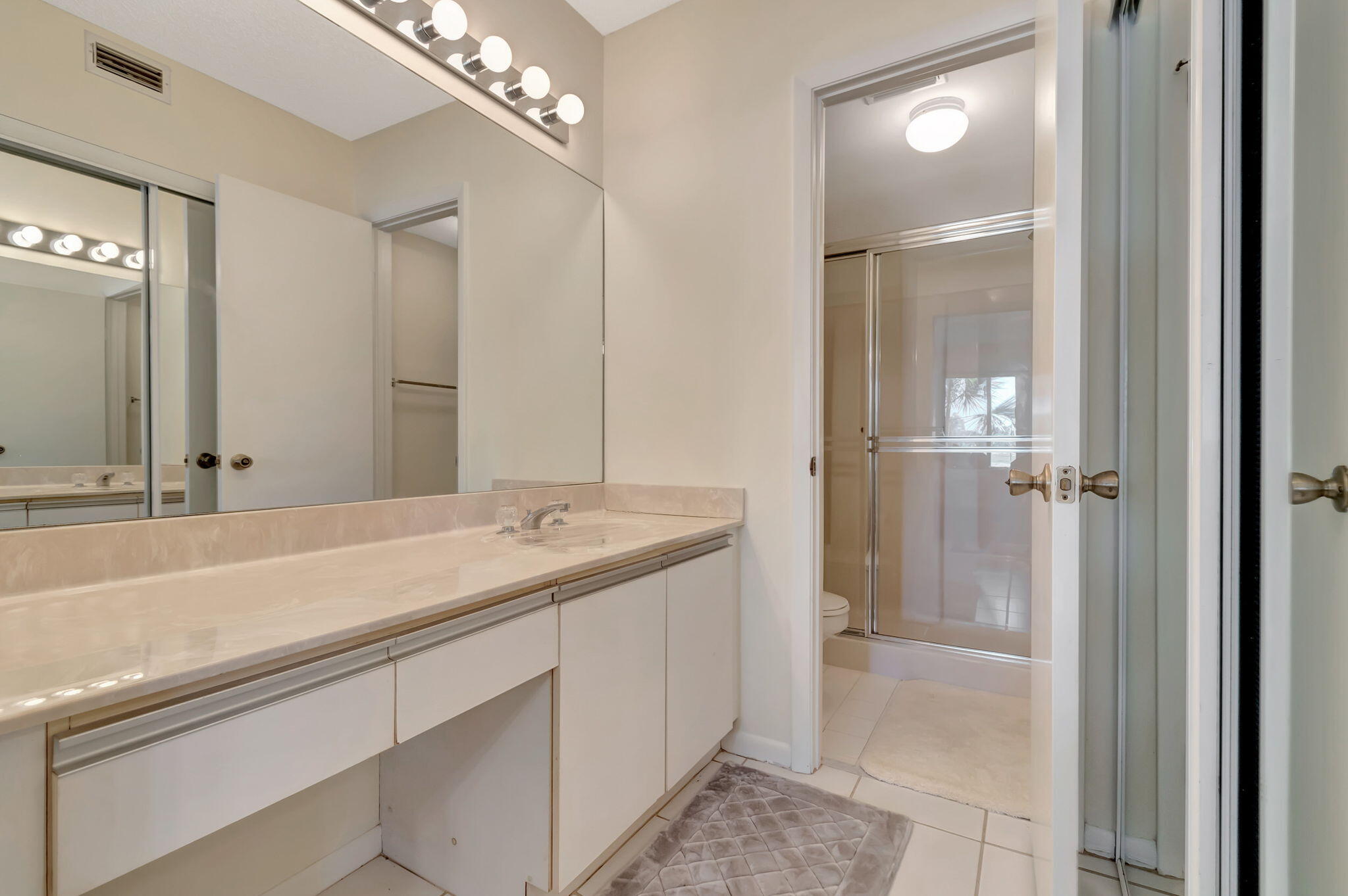 280 Northwest 67th Street, Unit B207 Boca Raton, FL 33487 - Photo 17 of 22 a bathroom with a sink and a mirror