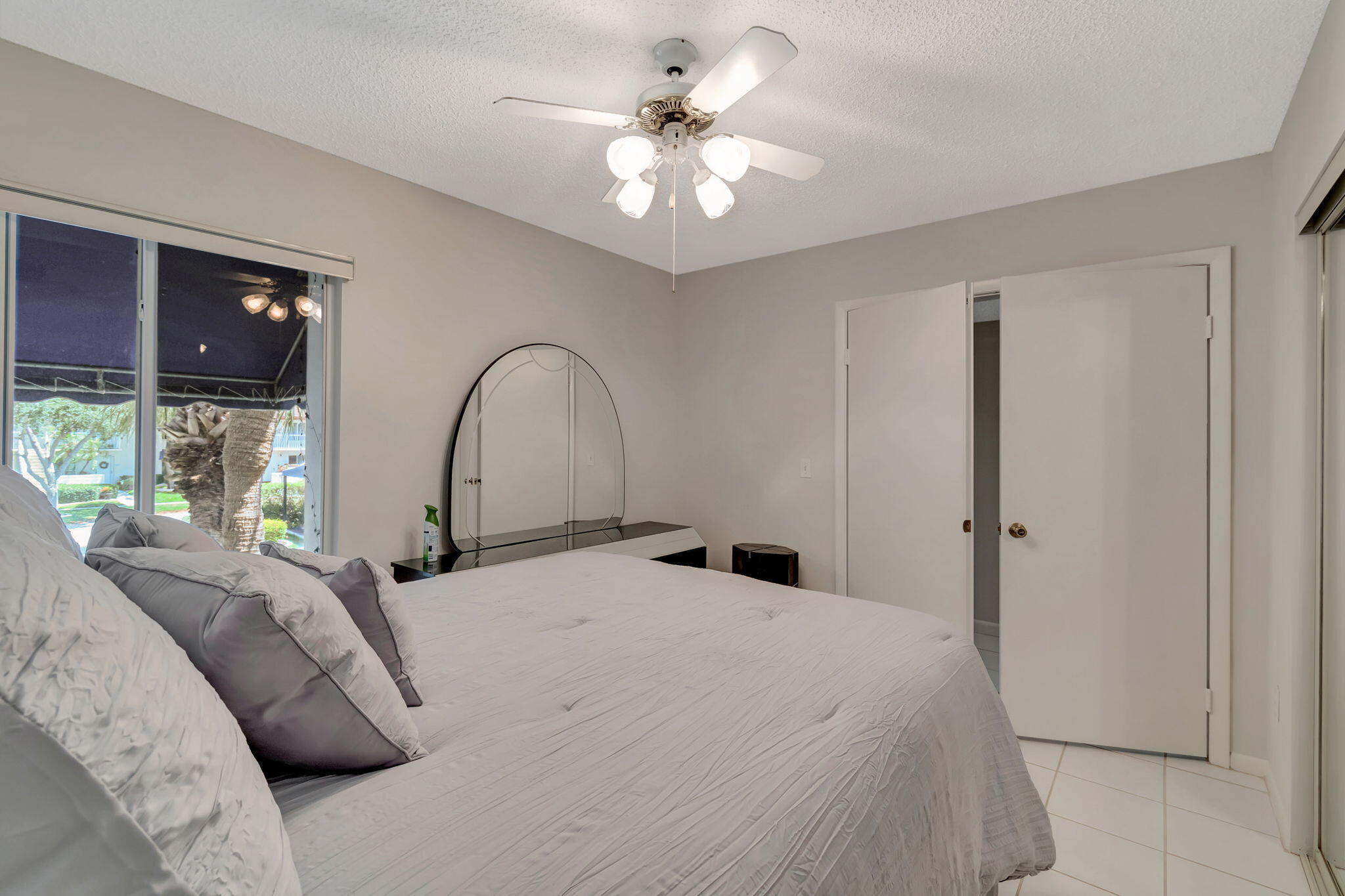280 Northwest 67th Street, Unit B207 Boca Raton, FL 33487 - Photo 21 of 22 a large bedroom with a bed and a chandelier