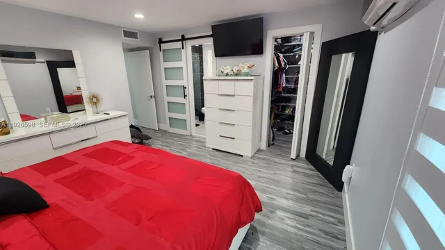 a bed room with a bed and a flat tv screen