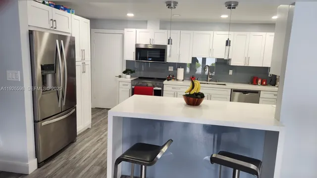 a kitchen with refrigerator and chairs