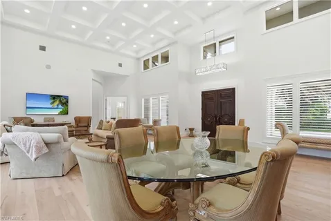 a living room with furniture and a dining table with wooden floor