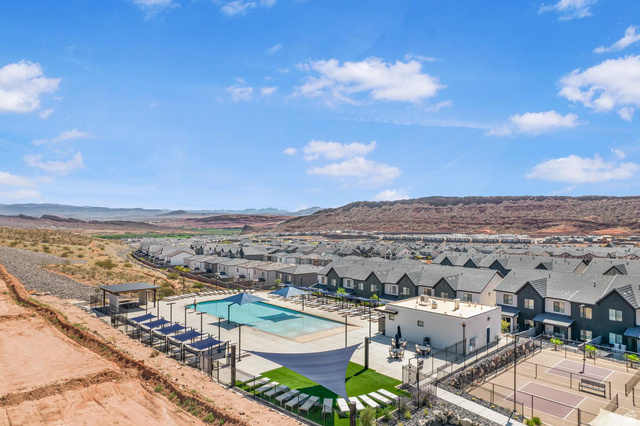 1705 Ripple Rock Drive, Unit 3017 Washington, UT 84780 - Photo 2 of 22 Community amenities featuring a swimming pool, shaded lounge areas, a covered pavilion, and sports courts, all surrounded by contemporary townhome-style residences and a desert landscape