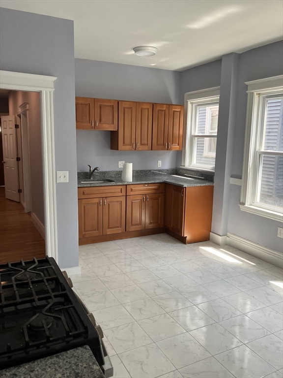 29 Cottage Street Chelsea, MA 02150 - Photo 17 of 24 a kitchen with granite countertop a stove and a sink