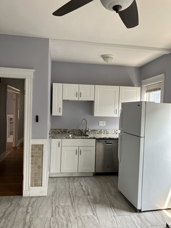 29 Cottage Street Chelsea, MA 02150 - Photo 18 of 24 a kitchen with granite countertop a refrigerator sink stove and cabinets