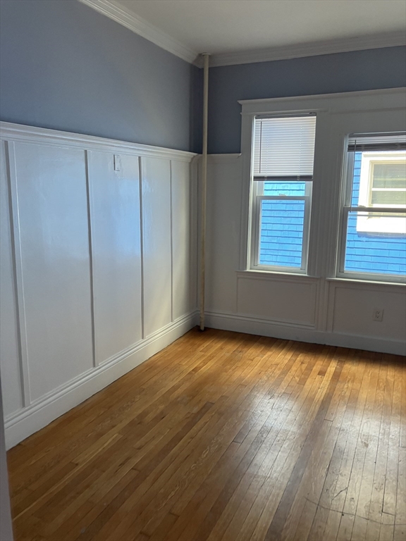 29 Cottage Street Chelsea, MA 02150 - Photo 19 of 24 a view of an empty room with wooden floor and a window