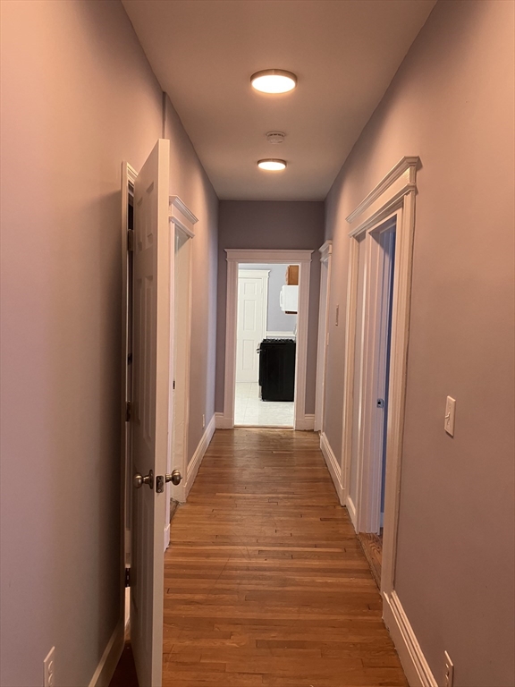 29 Cottage Street Chelsea, MA 02150 - Photo 21 of 24 a view of a hallway with wooden floor and staircase