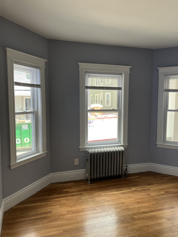 29 Cottage Street Chelsea, MA 02150 - Photo 22 of 24 a view of an empty room with wooden floor and a window