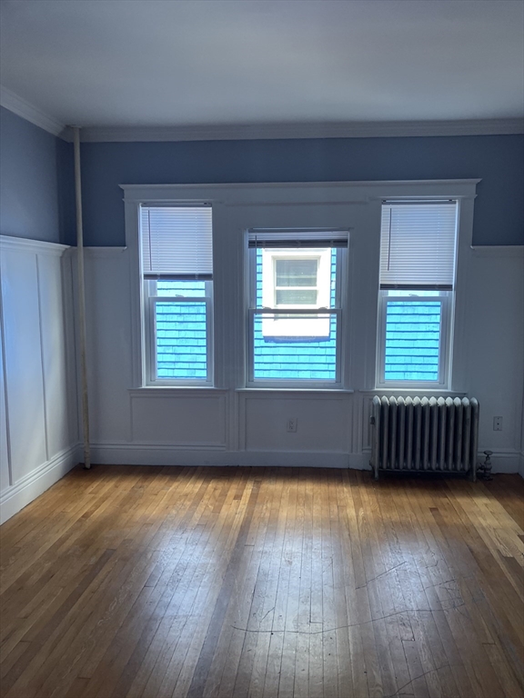 29 Cottage Street Chelsea, MA 02150 - Photo 23 of 24 an empty room with wooden floor and windows