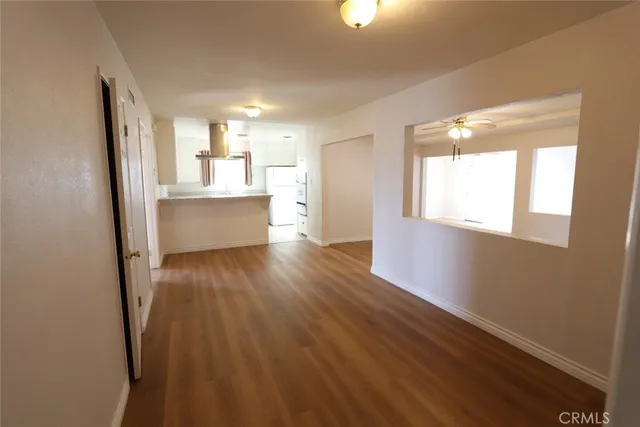 a view of a kitchen with wooden floor and a window