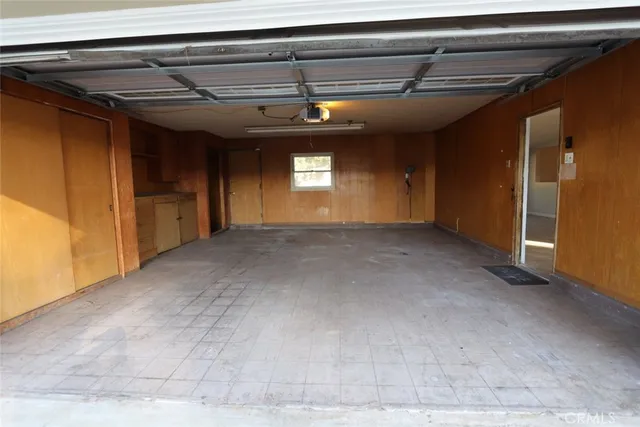 a view of a hallway with wooden floor and a refrigerator