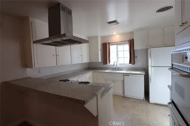 a kitchen with stainless steel appliances a stove a sink a refrigerator and cabinets