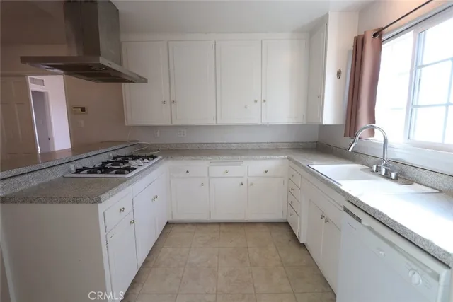 a kitchen with granite countertop a sink stove and cabinets