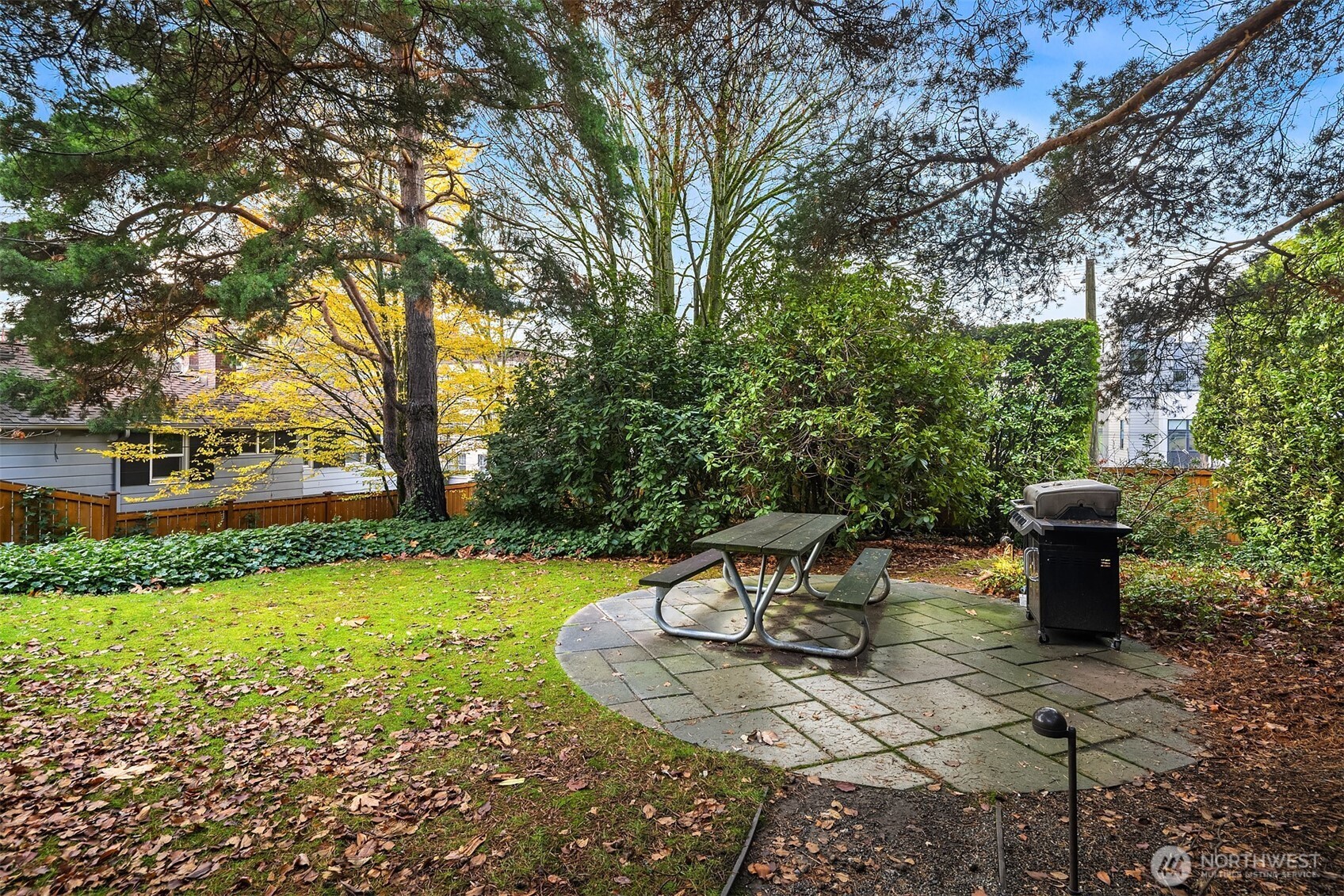 1631 16th Avenue, Unit 309 Seattle, WA 98122 - Photo 20 of 23 a view of a backyard with table and chairs potted plants and large tree