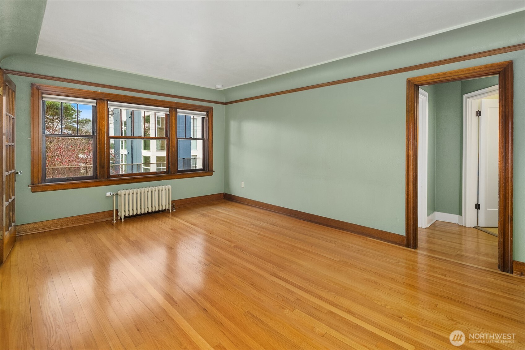 1631 16th Avenue, Unit 309 Seattle, WA 98122 - Photo 7 of 23 a view of an empty room with wooden floor and a window