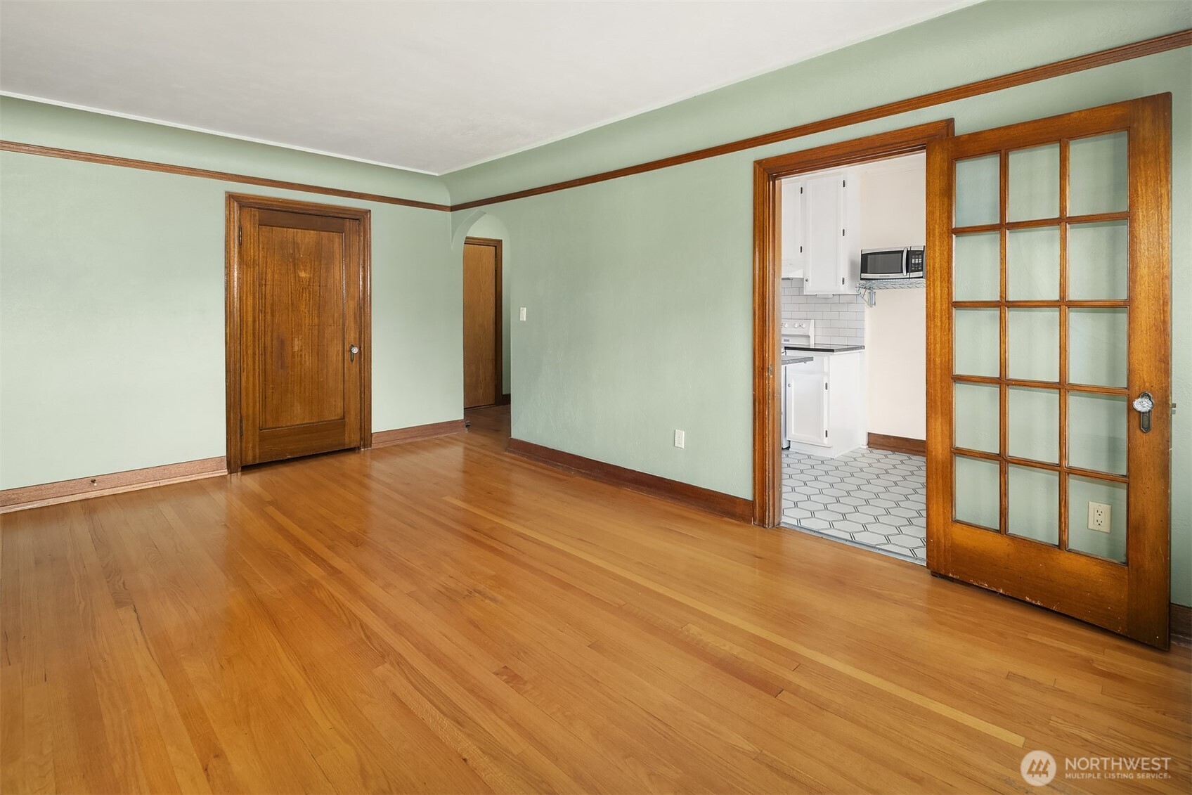 1631 16th Avenue, Unit 309 Seattle, WA 98122 - Photo 9 of 23 a view of an empty room with window and wooden floor