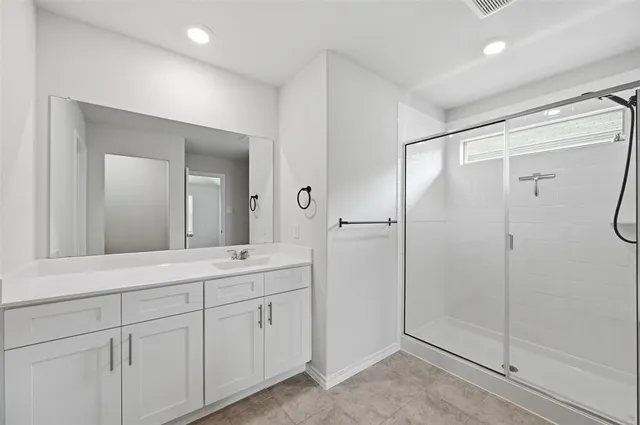 a bathroom with a shower sink and mirror